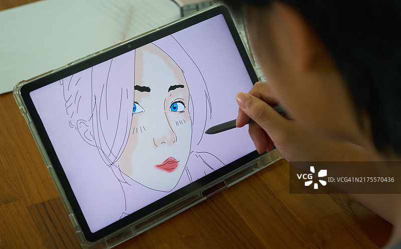 年轻女人在平板电脑上绘制女性形象图片素材