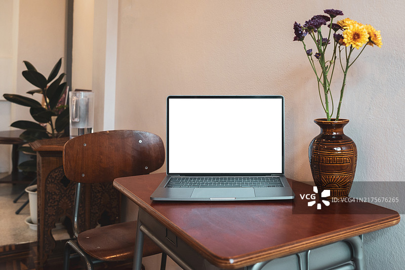 咖啡馆背景中桌子上的笔记本电脑空白屏幕图片素材