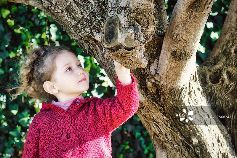 在美国乡村站在树旁的可爱白人女孩图片素材