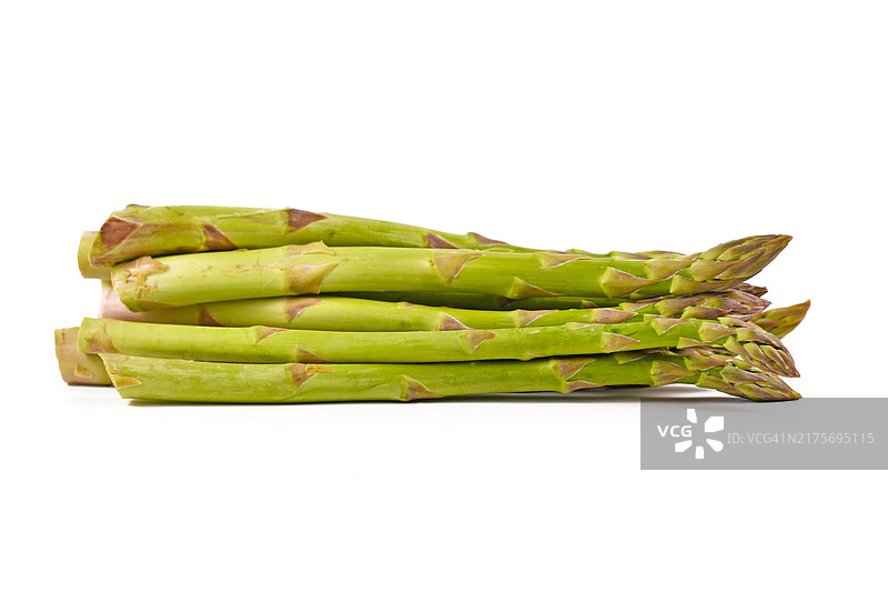 白色背景下，一堆生的绿色芦笋蔬菜的侧视图图片素材