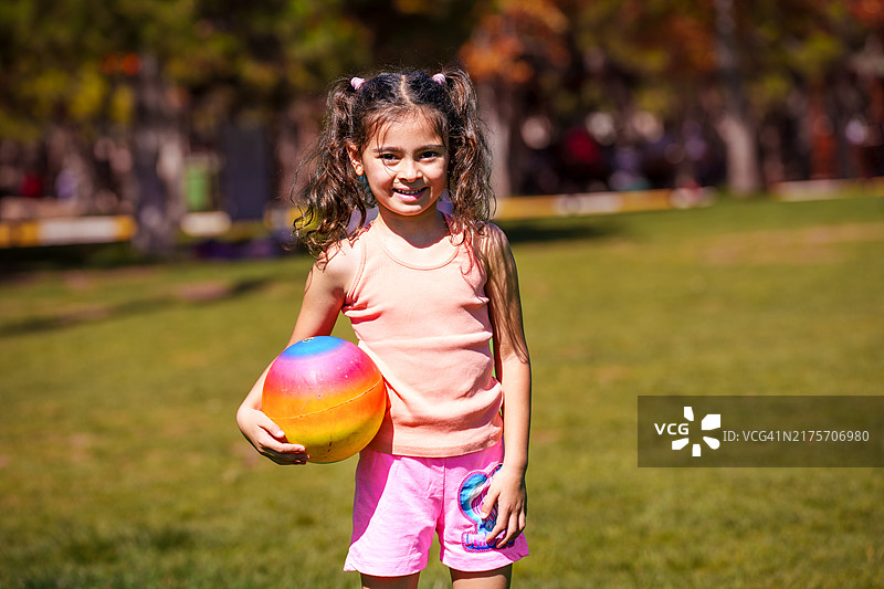 小女孩拿着彩色球摆姿势图片素材