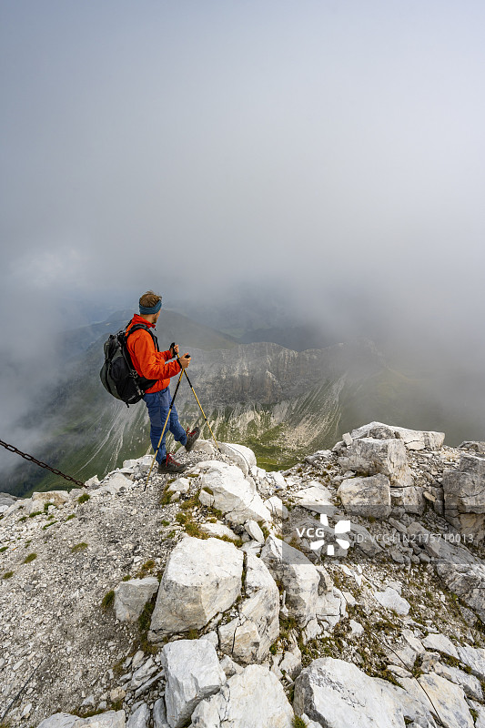 登山者攀登狭窄山脊，阴云笼罩山峰，卡尼克主山脊，卡尼克高地之路，卡尼克阿尔卑斯山，克恩顿州，奥地利，欧洲图片素材