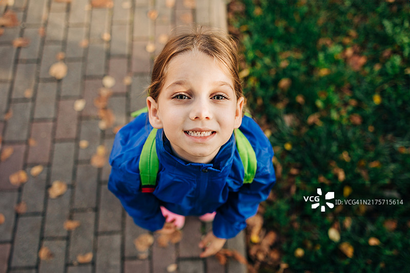 秋天里背着背包的小女孩（俯视视角）图片素材