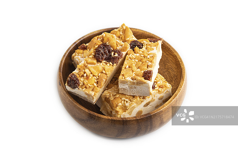 白色背景中分离的带坚果和芝麻的传统糖果牛轧糖。侧视图，特写图片素材