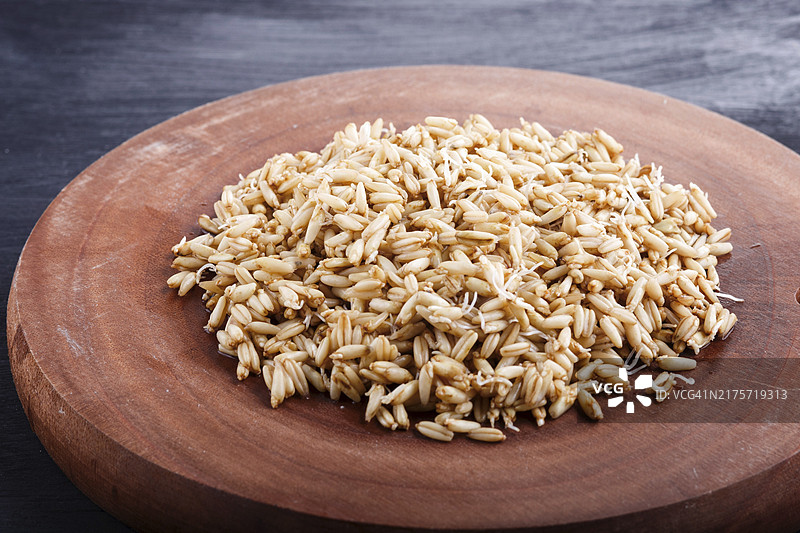 棕色木板上的一堆发芽燕麦，特写，侧视图图片素材