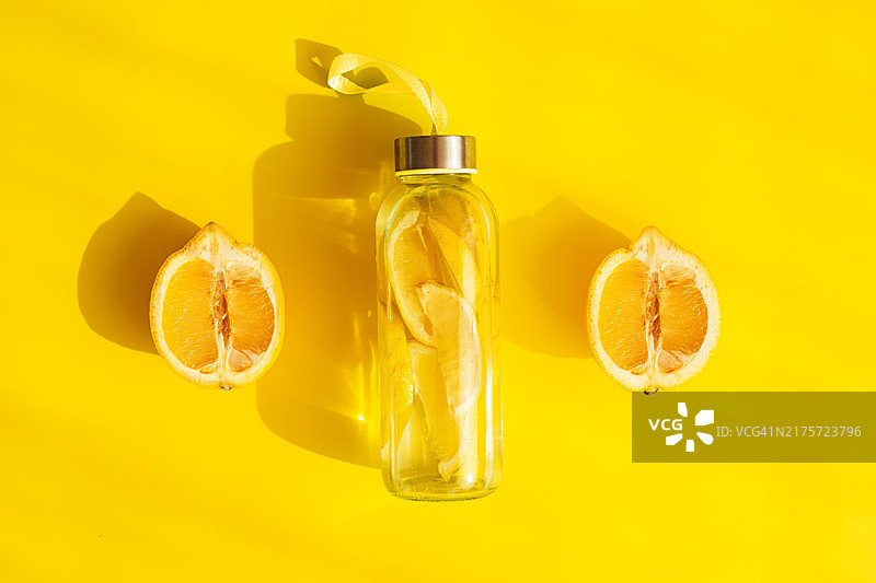 柠檬水在鲜艳的黄色背景上，清新的画面非常适合推广健康生活。图片素材