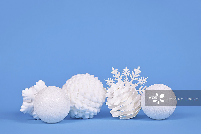 蓝色背景上的白色圣诞树装饰品，含复制空间图片素材