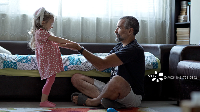 父女共舞：爸爸和女儿一起快乐地跳舞图片素材