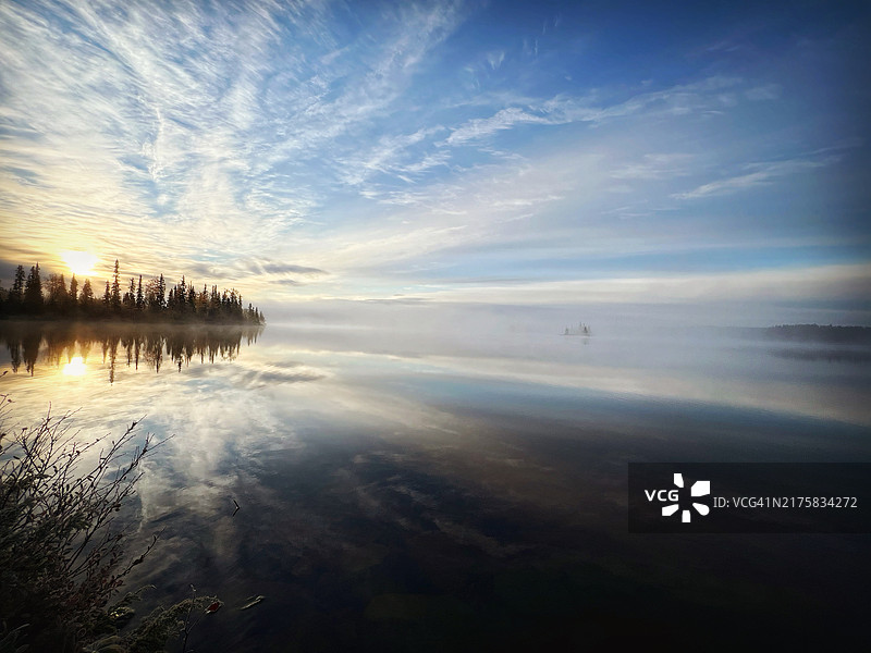 倒影湖面上的雾中日出图片素材