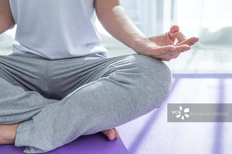 男人在瑜伽垫上以莲花姿势冥想图片素材