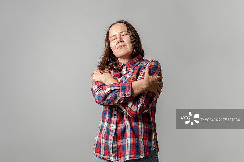 穿着格子衬衫的女人自我拥抱图片素材