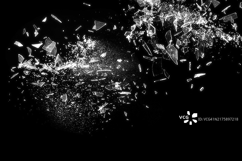 黑色背景上的破碎玻璃，展示了破碎玻璃的抽象纹理细节，该图像非常适合用于背景、纹理或抽象艺术项目图片素材
