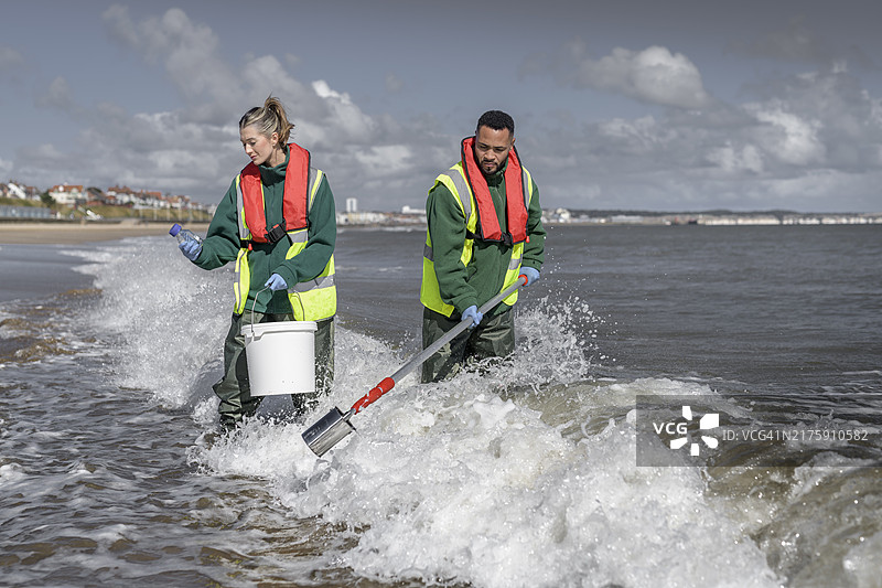 环境工作者从海中提取水样，检查污水污染、大肠杆菌和肠球菌，英格兰布里德灵顿图片素材