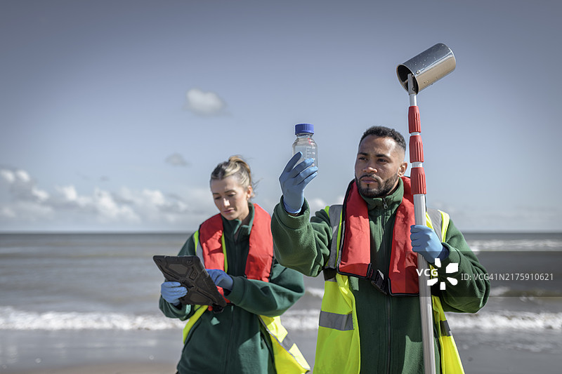 环境工作者从海中提取水样，检查污水污染、大肠杆菌和肠球菌，英格兰布里德灵顿图片素材