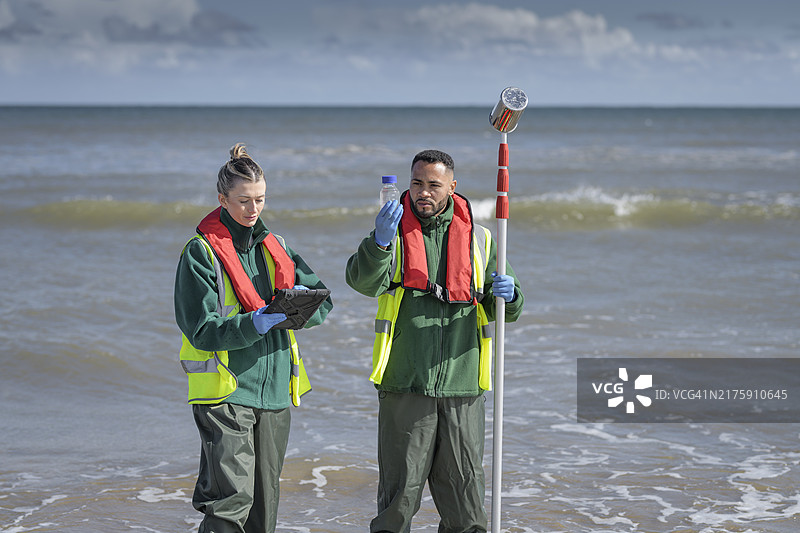 环境工作者从海中提取水样，检查污水污染、大肠杆菌和肠球菌，英格兰布里德灵顿图片素材