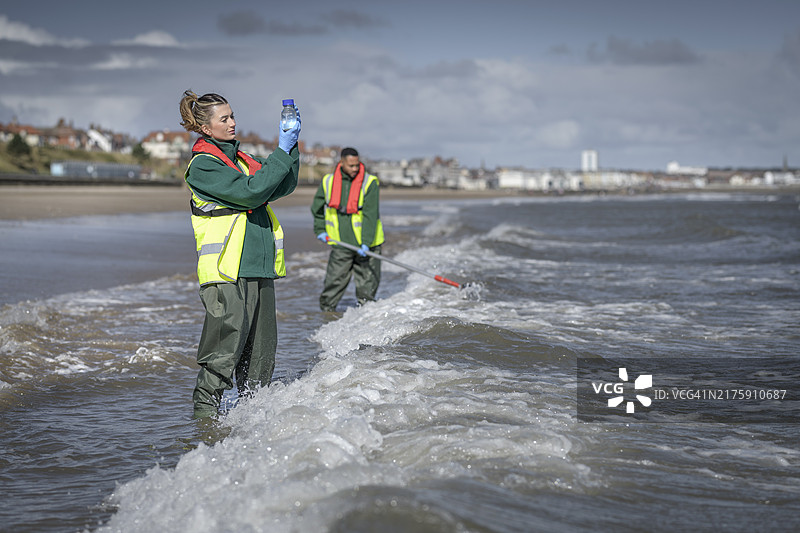 环境工作者从海中提取水样，检查污水污染、大肠杆菌和肠球菌，英格兰布里德灵顿图片素材