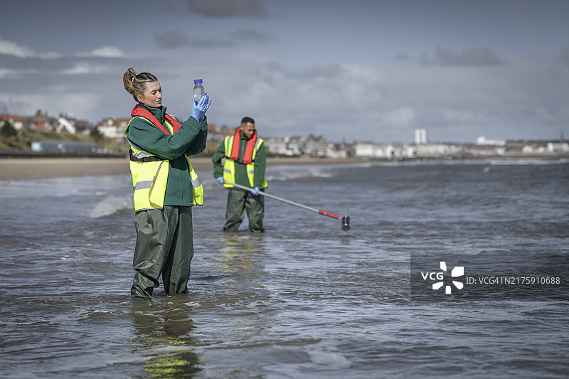 环境工作者从海中提取水样，检查污水污染、大肠杆菌和肠球菌，英格兰布里德灵顿图片素材