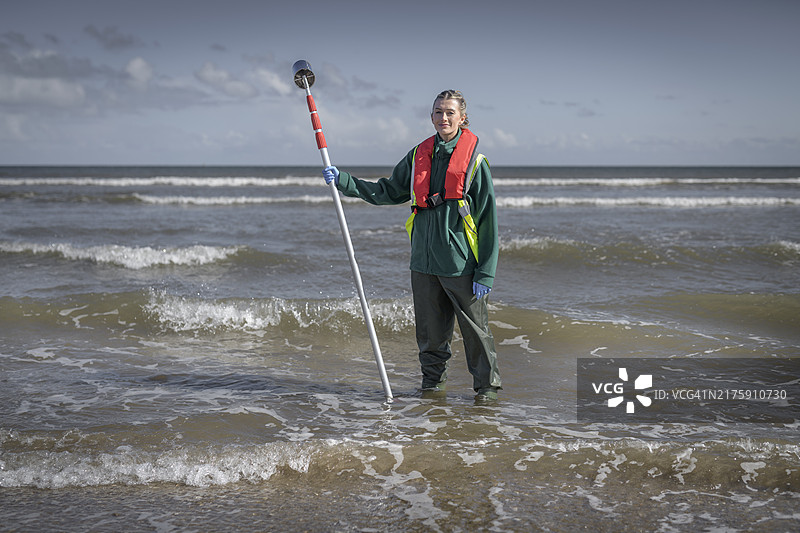 环境工作者在英格兰布里德灵顿从海水中取水样，检查污水污染、大肠杆菌和肠球菌的肖像图片素材