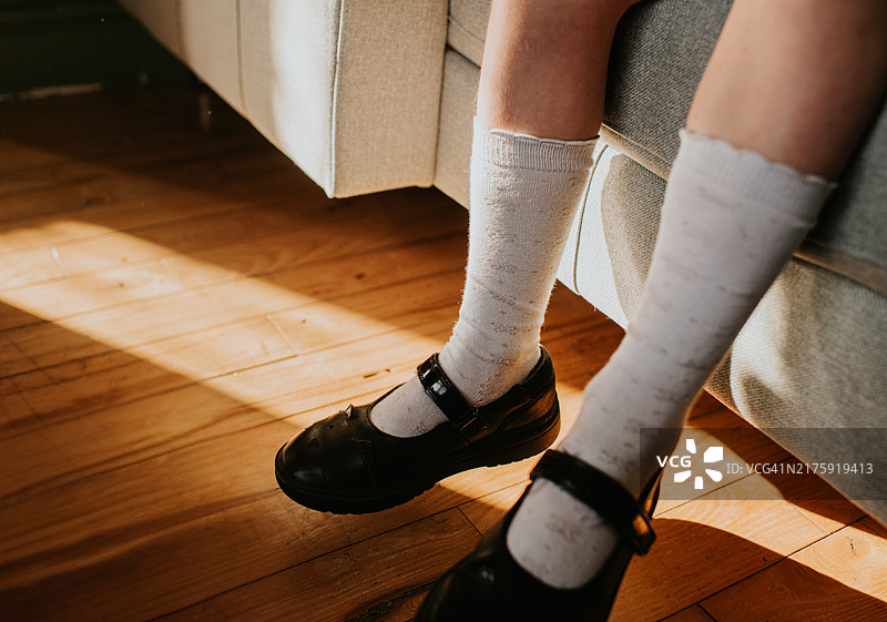 孩子穿着黑色校鞋和白色袜子在沙发上放松图片素材