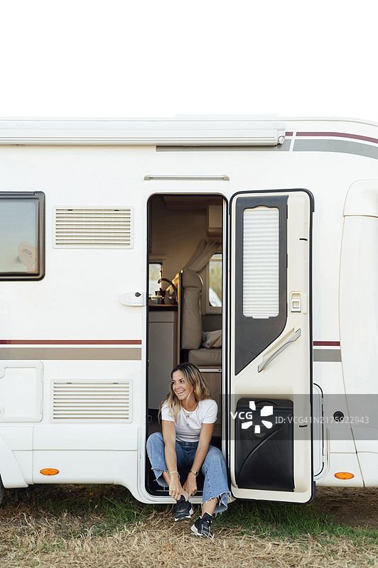 女人在房车门口系鞋带图片素材