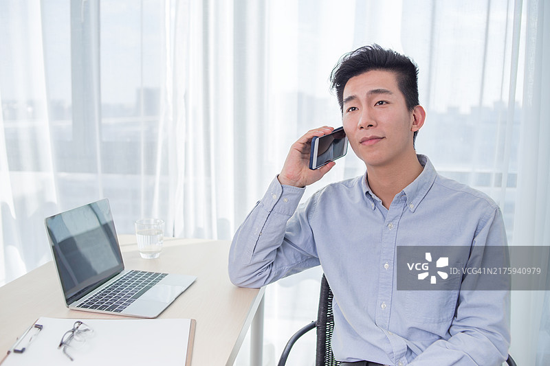 在办公室使用手机的年轻男人图片素材
