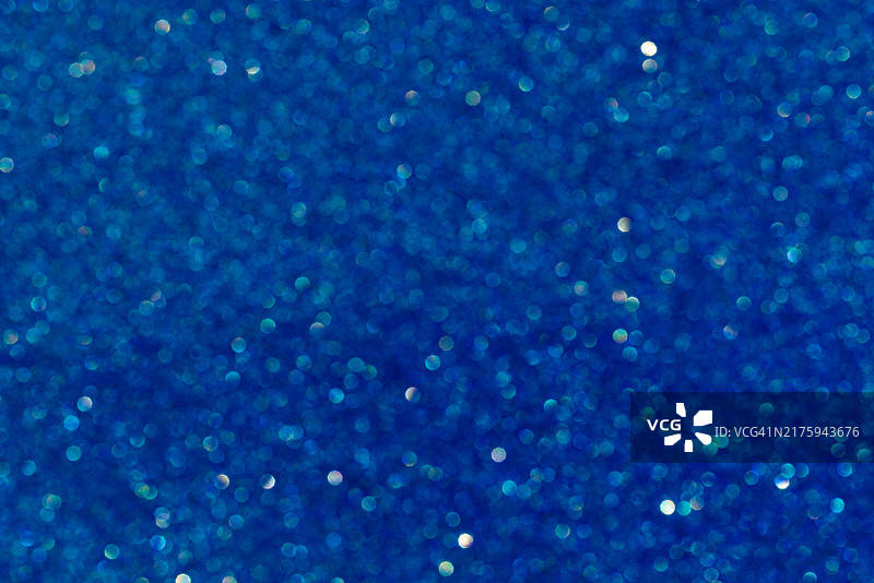 深色背景上闪耀的蓝色粒子，营造出抽象效果图片素材