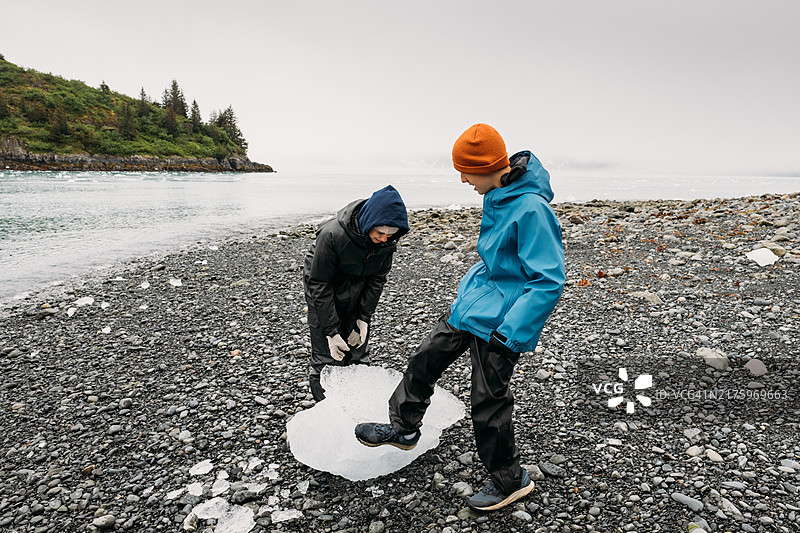 青少年兄弟姐妹在阿拉斯加玩一块浮冰图片素材