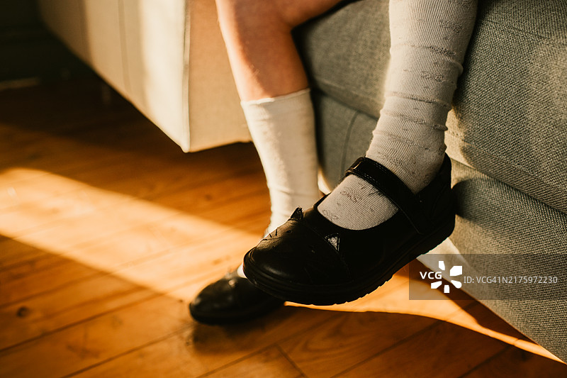 孩子穿着黑色校鞋和白色袜子在沙发上放松图片素材