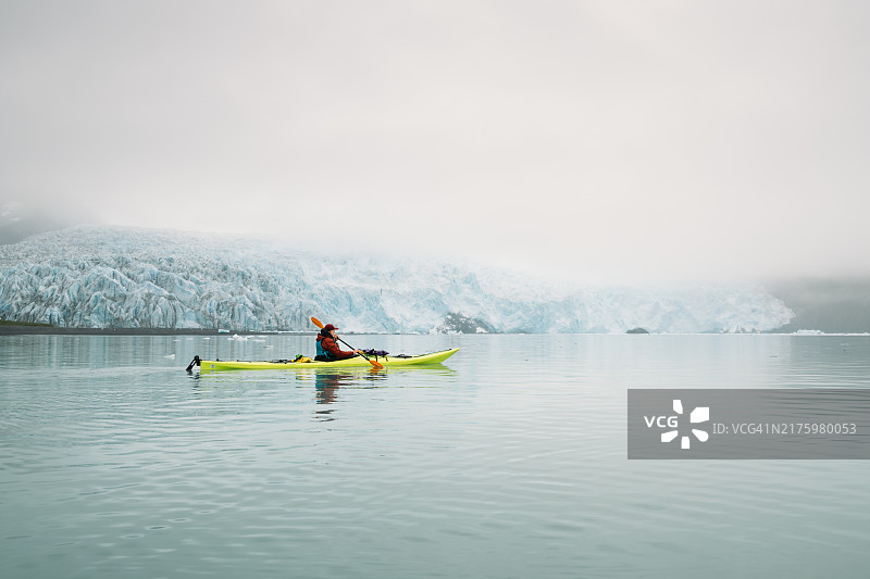 在阿拉斯加冰川附近划皮划艇的女人图片素材