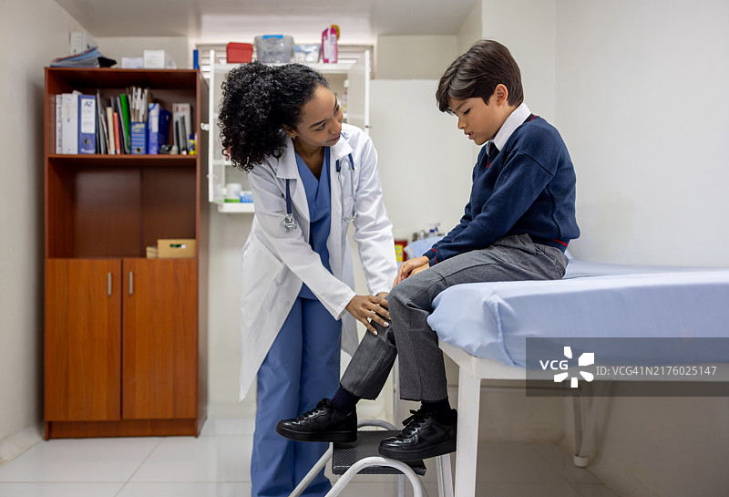 护士检查在学校受伤膝盖的男孩图片素材
