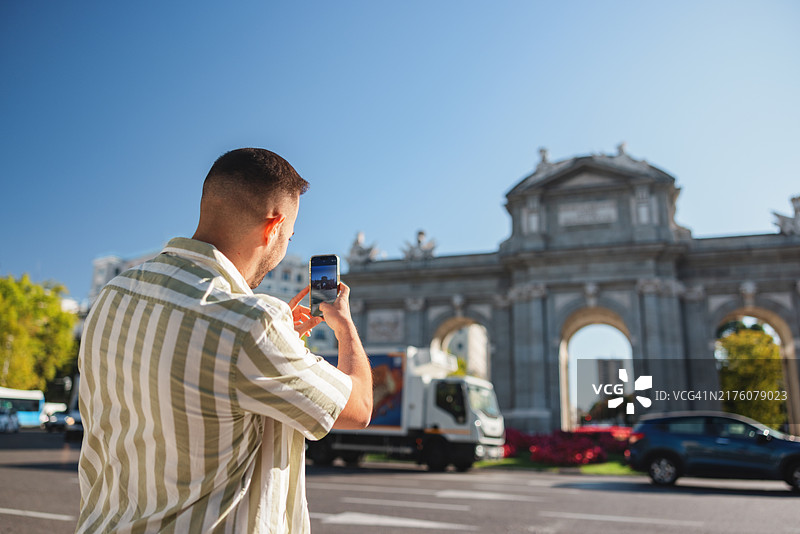西班牙裔男子在马德里拍摄阿尔卡拉门图片素材
