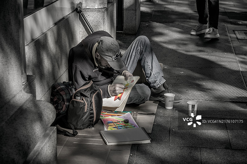在街上绘画的无家可归的男人图片素材