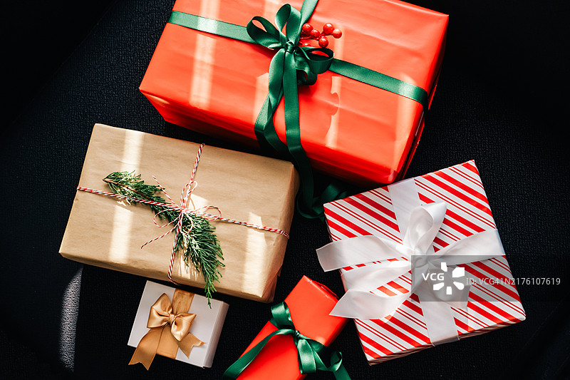 黑色背景下的不同圣诞礼物，顶视图，阳光明媚图片素材