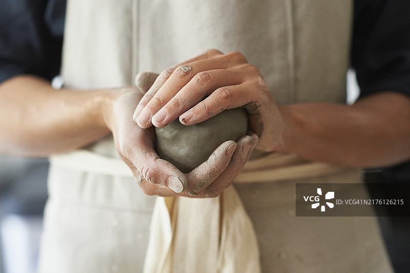 陶艺师手中拿着泥球的特写图片素材