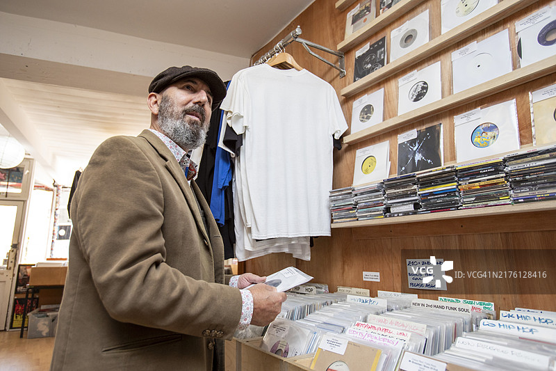 男人在唱片店里翻找黑胶唱片图片素材