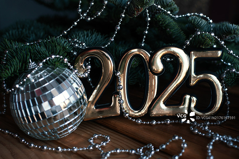 2025年新年圣诞节假日：带有圣诞树枝的纯色背景上的2025新年数字图片素材