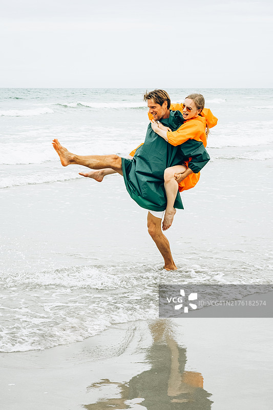 在乡村风格的木洗手池中，双手被清洗，周围环绕着郁郁葱葱的植物。自然光线和环保的环境。图片素材