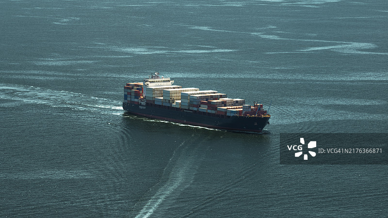 在绿色海水中航行的集装箱货轮，为货运港口服务图片素材