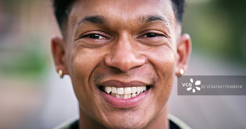 在公园里使用笔记本电脑微笑的非洲男人图片素材