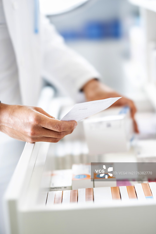 药剂师手持处方为患者选药特写图片素材