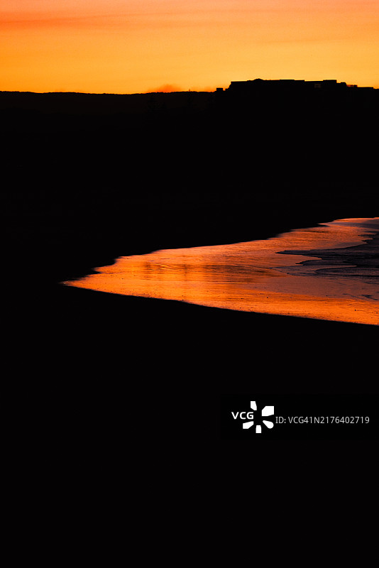 日落映照在太平洋拍打基拉海滩的波浪上，库兰达，黄金海岸，昆士兰，澳大利亚图片素材