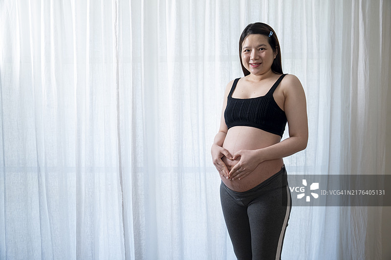 孕妇手捧腹部的半身像图片素材