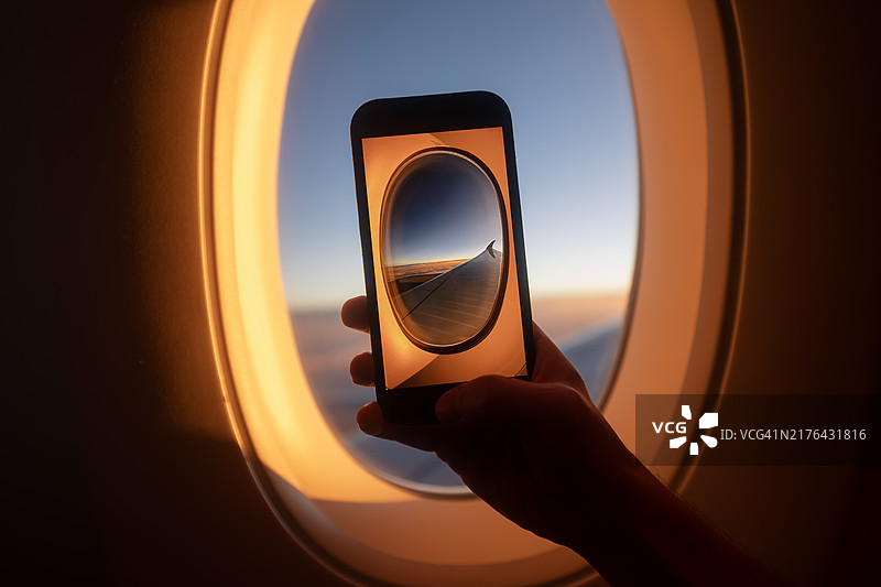 乘客在飞机窗口拍摄日落图片素材