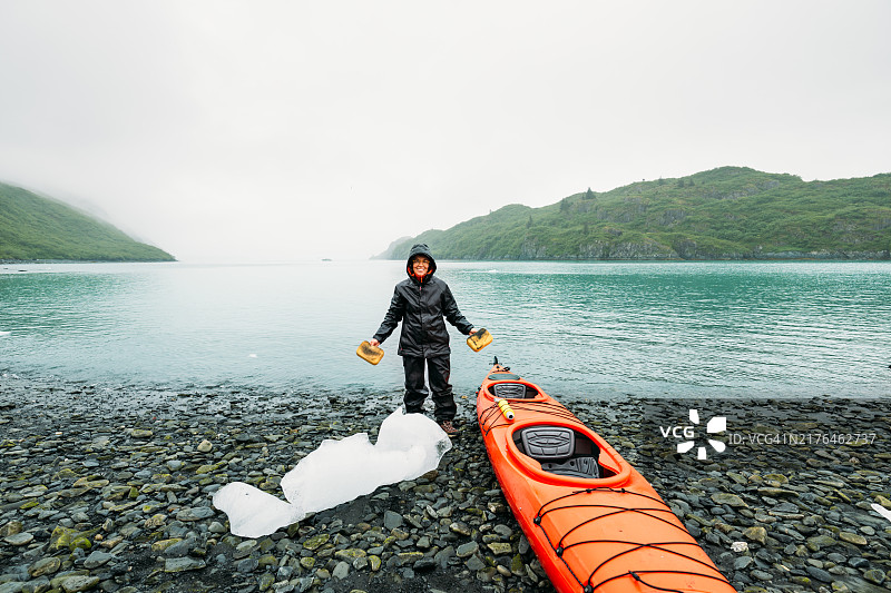 成熟的女性在阿拉斯加冰川探险后清洗皮划艇图片素材