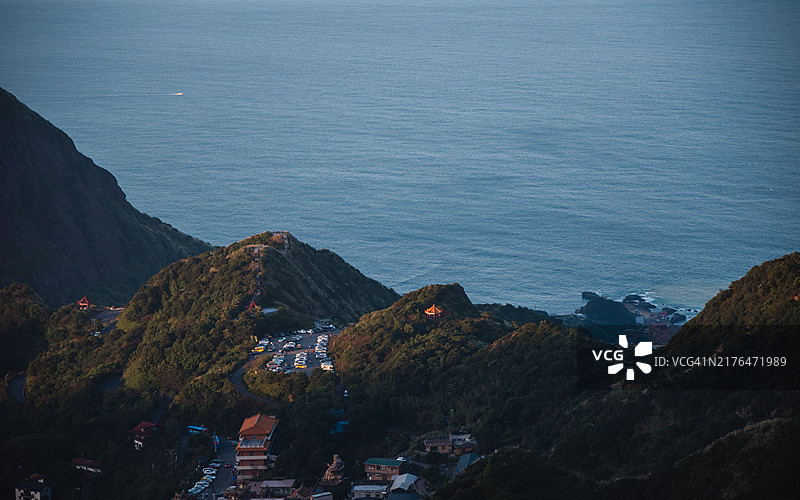 从九份俯瞰金瓜石地区，秋季的茶壶山（无耳茶壶山）上盛开着芒草花图片素材