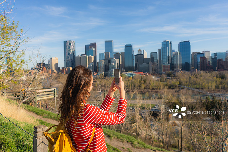 女人在卡尔加里市中心用智能手机摄影图片素材