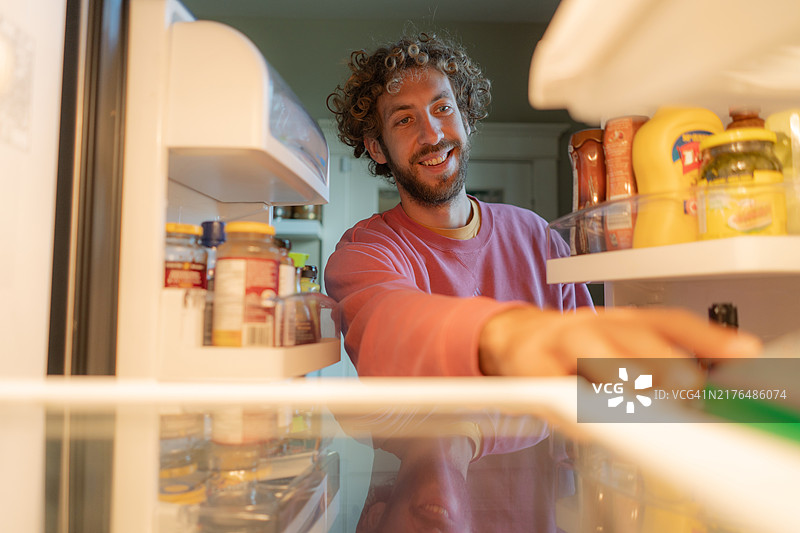 男人在冰箱里寻找农产品图片素材