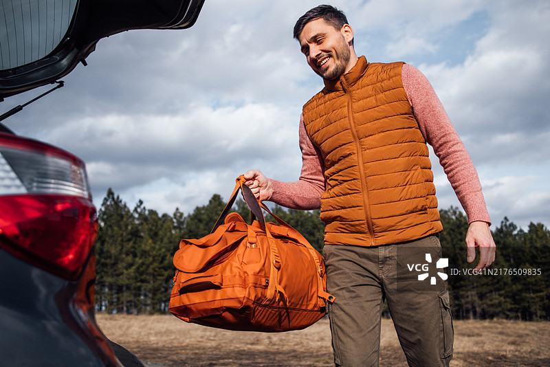 男人在山区为家庭度假打包汽车图片素材