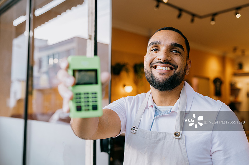 餐馆老板手持信用卡机的 портрет图片素材
