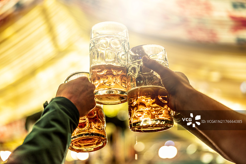 一群朋友在慕尼黑啤酒节上用大啤酒杯碰杯图片素材